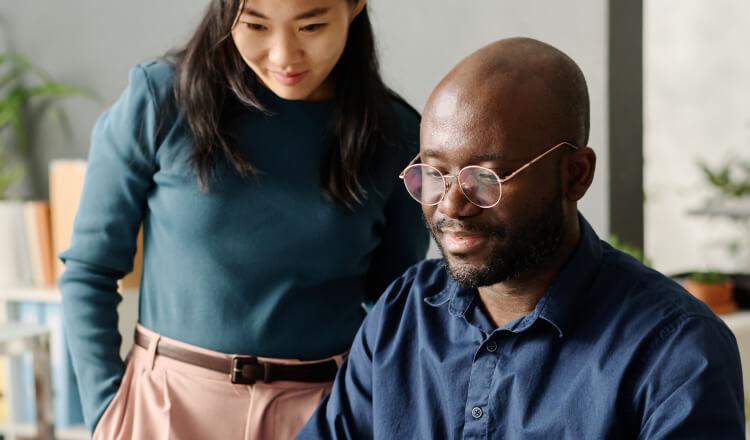 A person and a person looking at a computer.