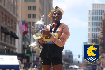 Boston Marathon winner lifting her cup trophy and logo for Boston Marathon