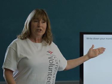Connie standing and presenting to others